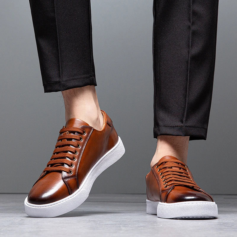 Close-up of man's legs in black trousers wearing brown leather Zoren sneakers with white soles