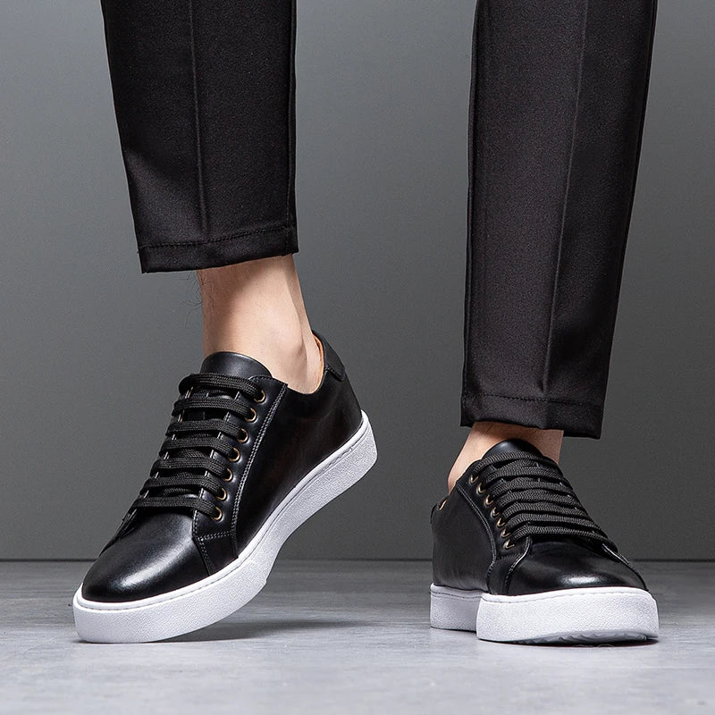 Close-up of man's legs in black trousers wearing black leather Zoren sneakers with white soles