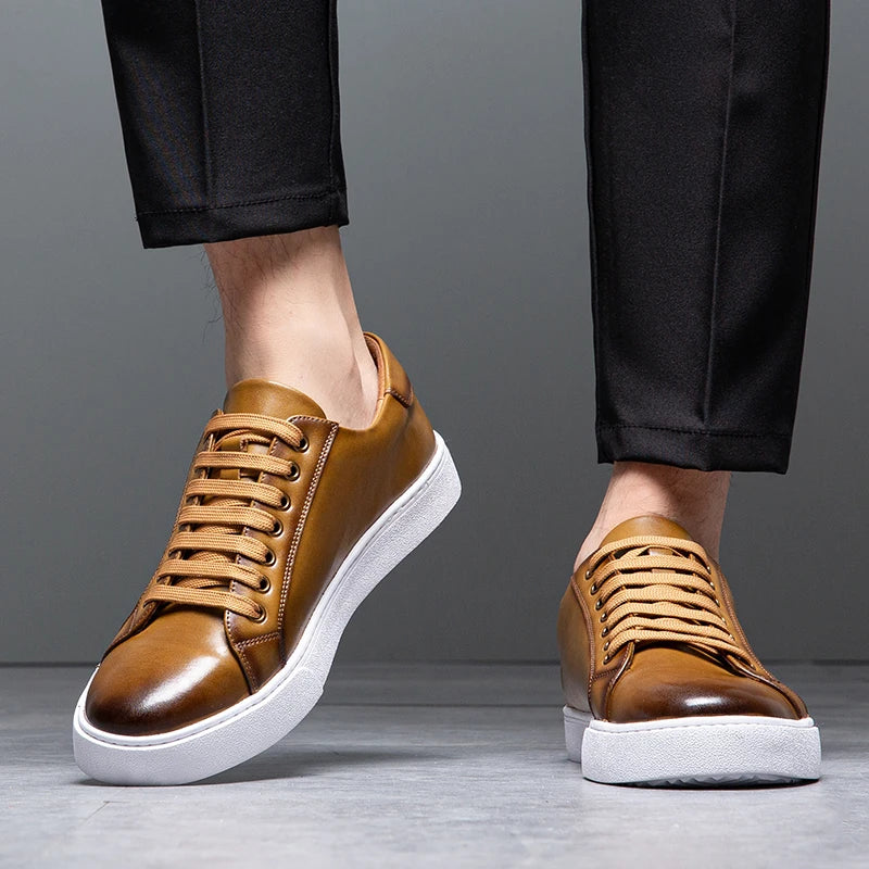 Close-up of man's legs in black trousers wearing tan leather Zoren sneakers with white soles
